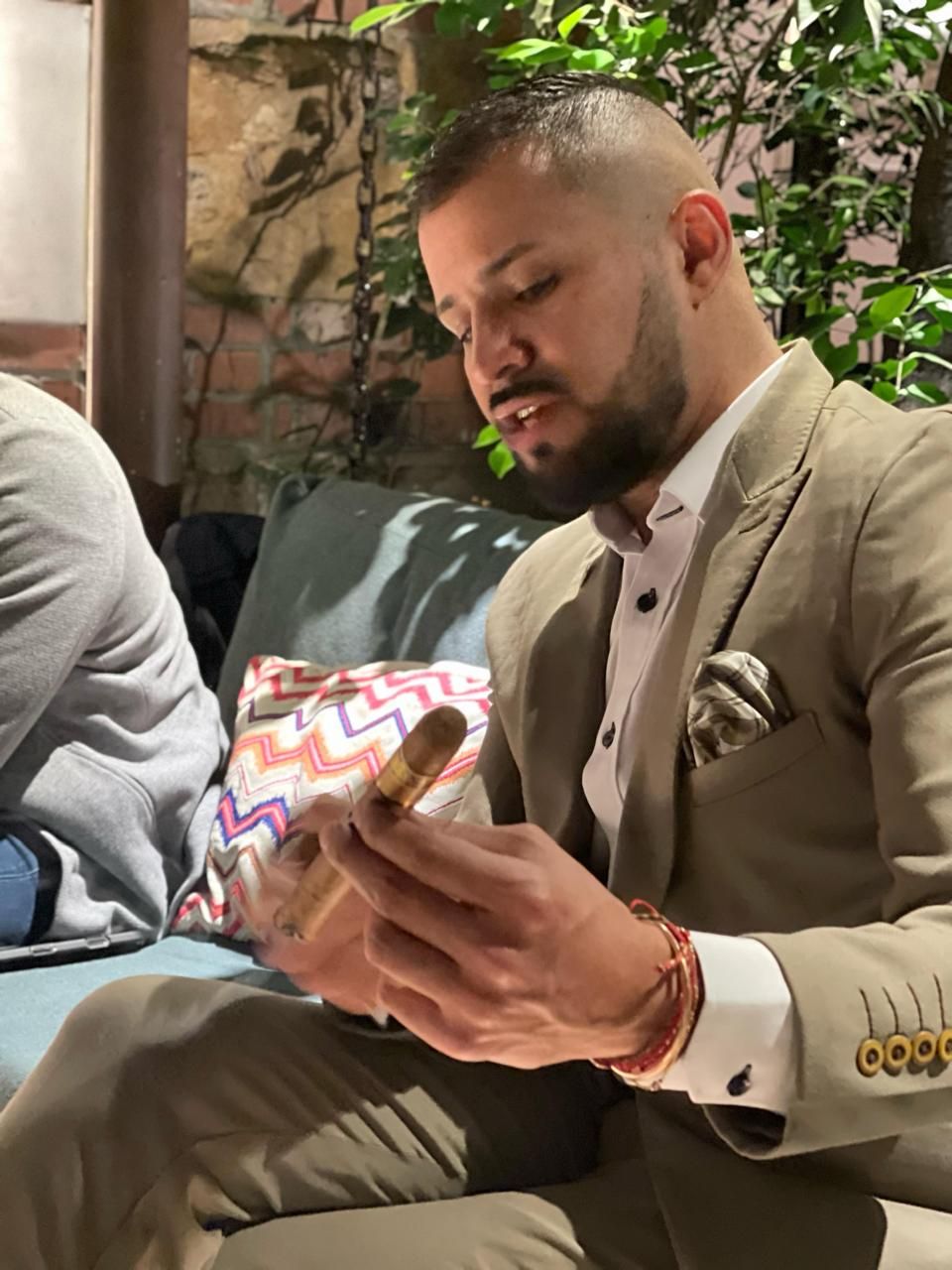 Alejandro examina un habano con atención